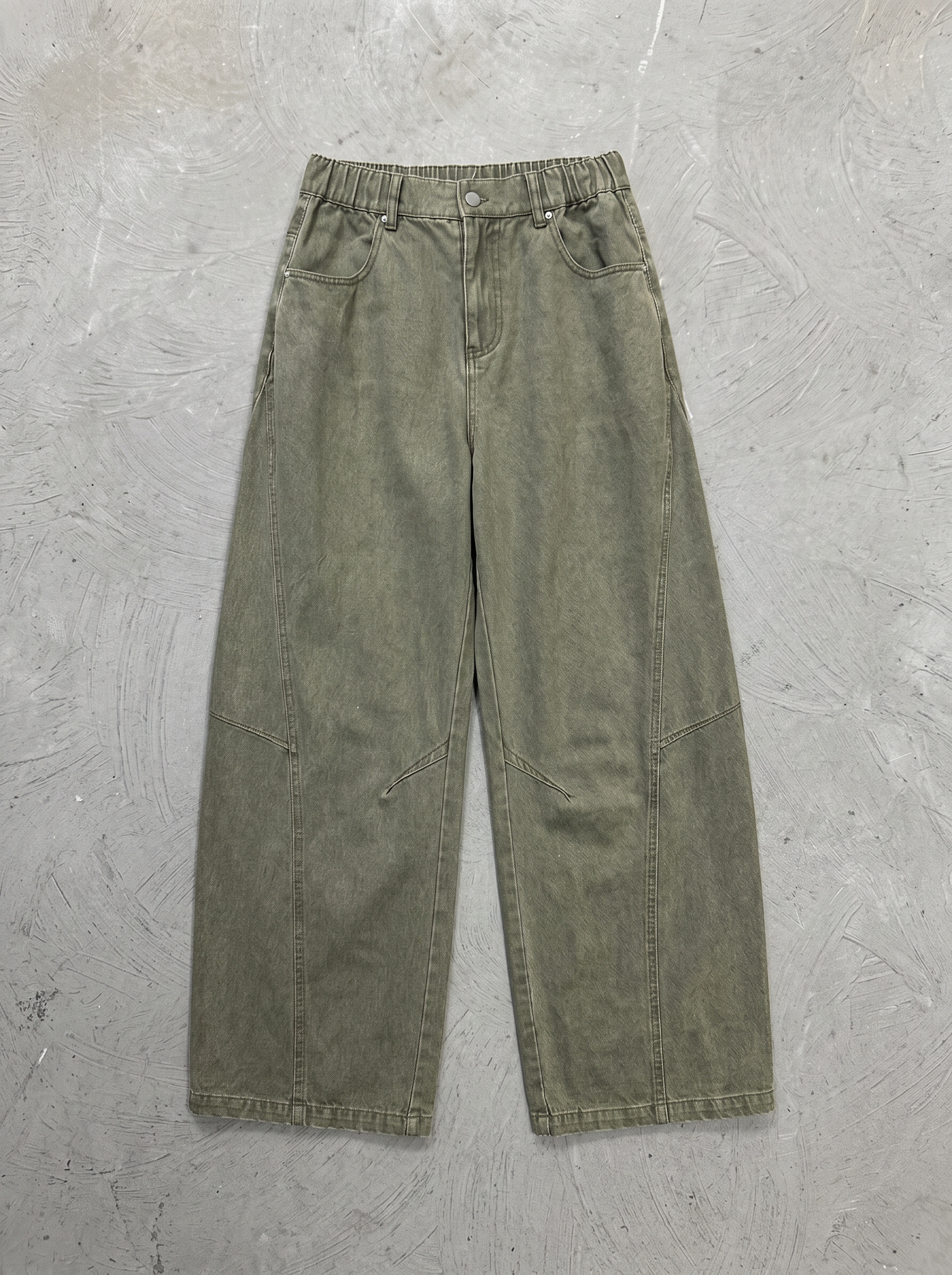 カーキにウォッシュをかけたバナナシルエットのワイドデニム正面の平置き。5ポケット、フロントフライ。腰から裾にかけて丸みのあるバナナラインのワイドレッグ。