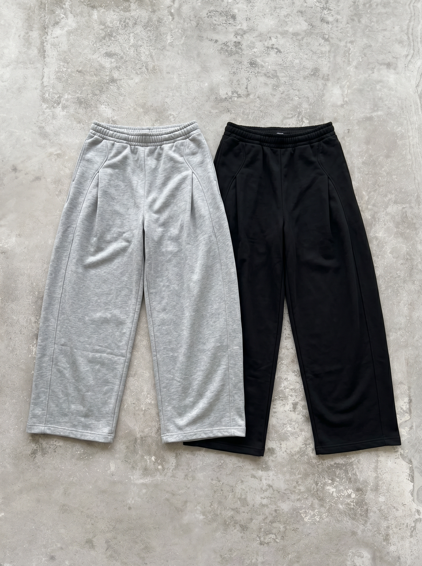 グレーとブラックのワイドスウェットパンツ2色の平置き。前面にタックを取ったワイドストレート。とろみのある落ち感の生地。