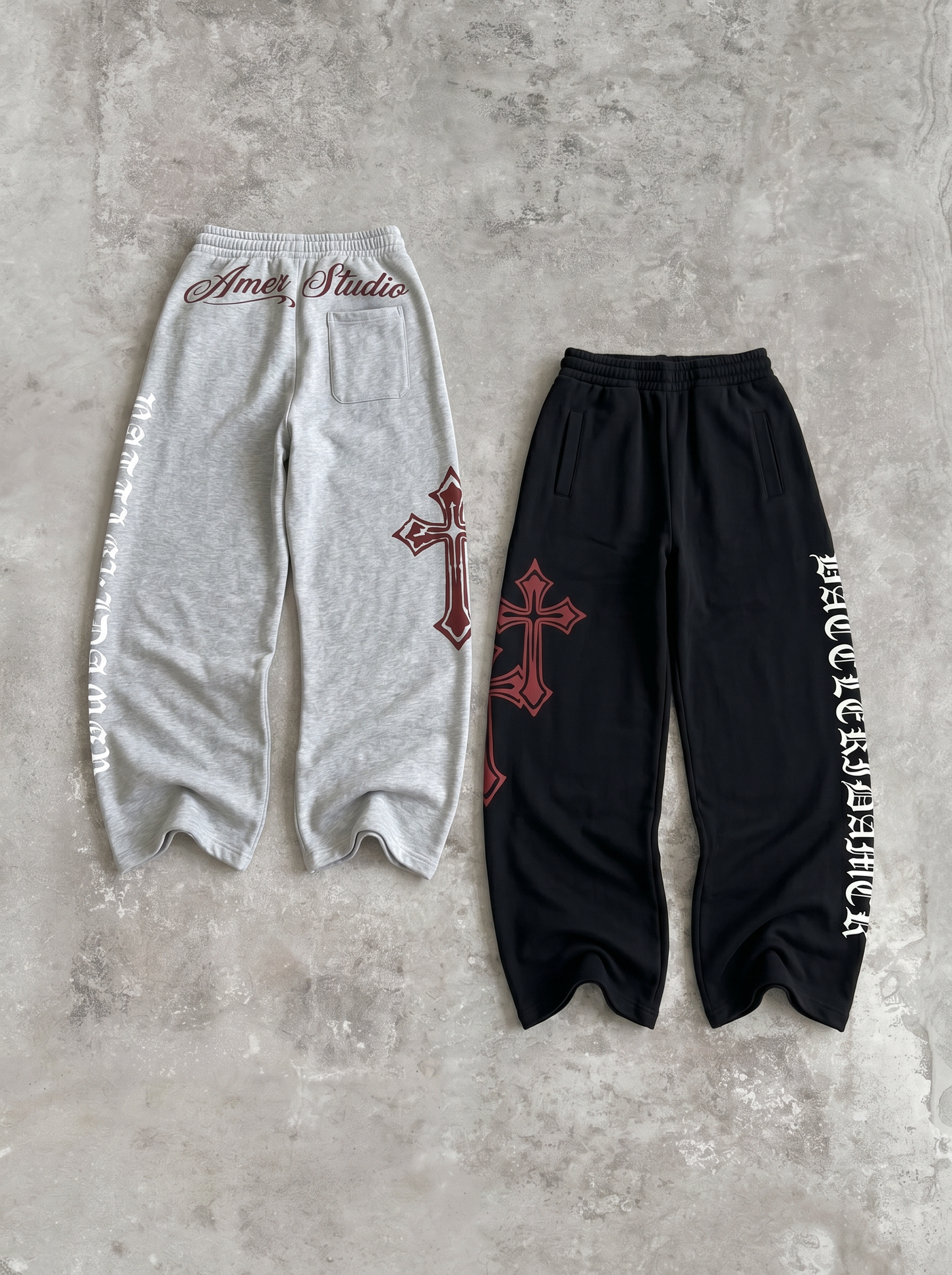 ヘザーグレーとブラックのワイドスウェットパンツ2色の平置き。裾にクロスのグラフィック、サイドにオールドイングリッシュ書体のレタリング。ドローコードのワイドストレート。