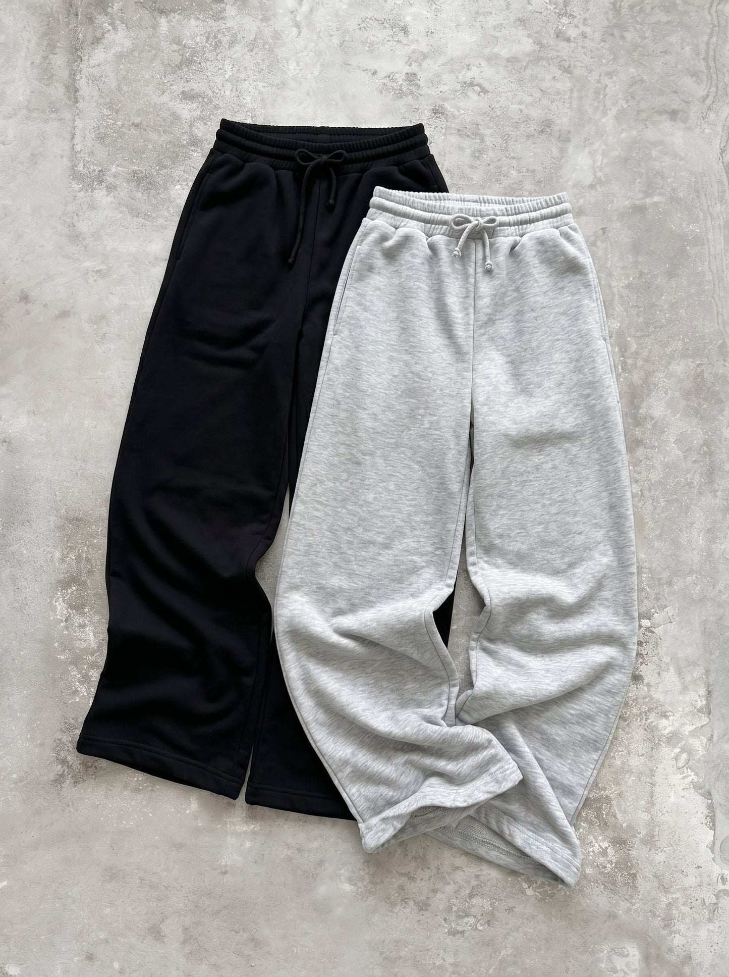 ヘザーグレーとブラックのワイドスウェットパンツ2色の平置き。ゴム+ドローコードのハイウエスト。ももから裾まで広がるワイドストレートシルエット。