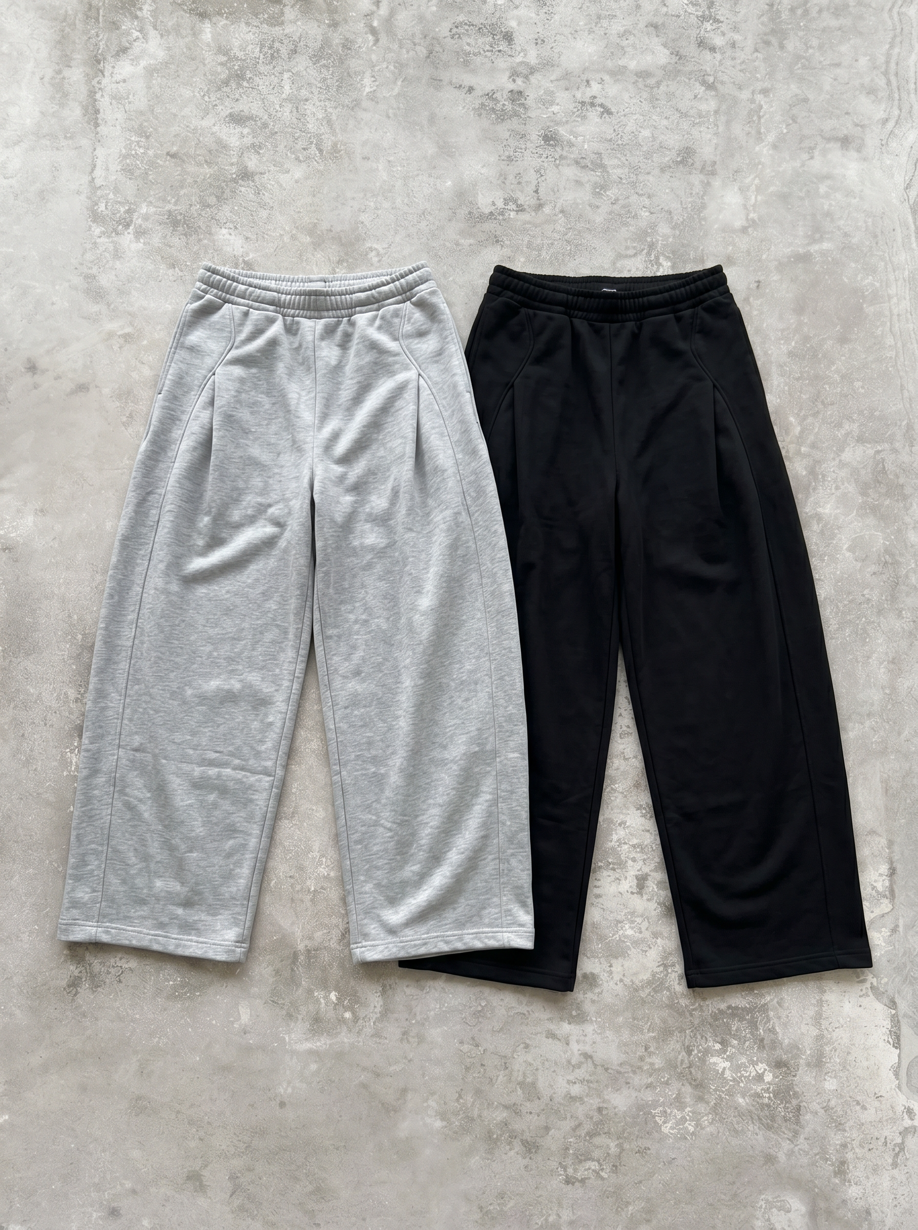 グレーとブラックのワイドスウェットパンツ2色の平置き。前面にタックを取ったワイドストレート。とろみのある落ち感の生地。