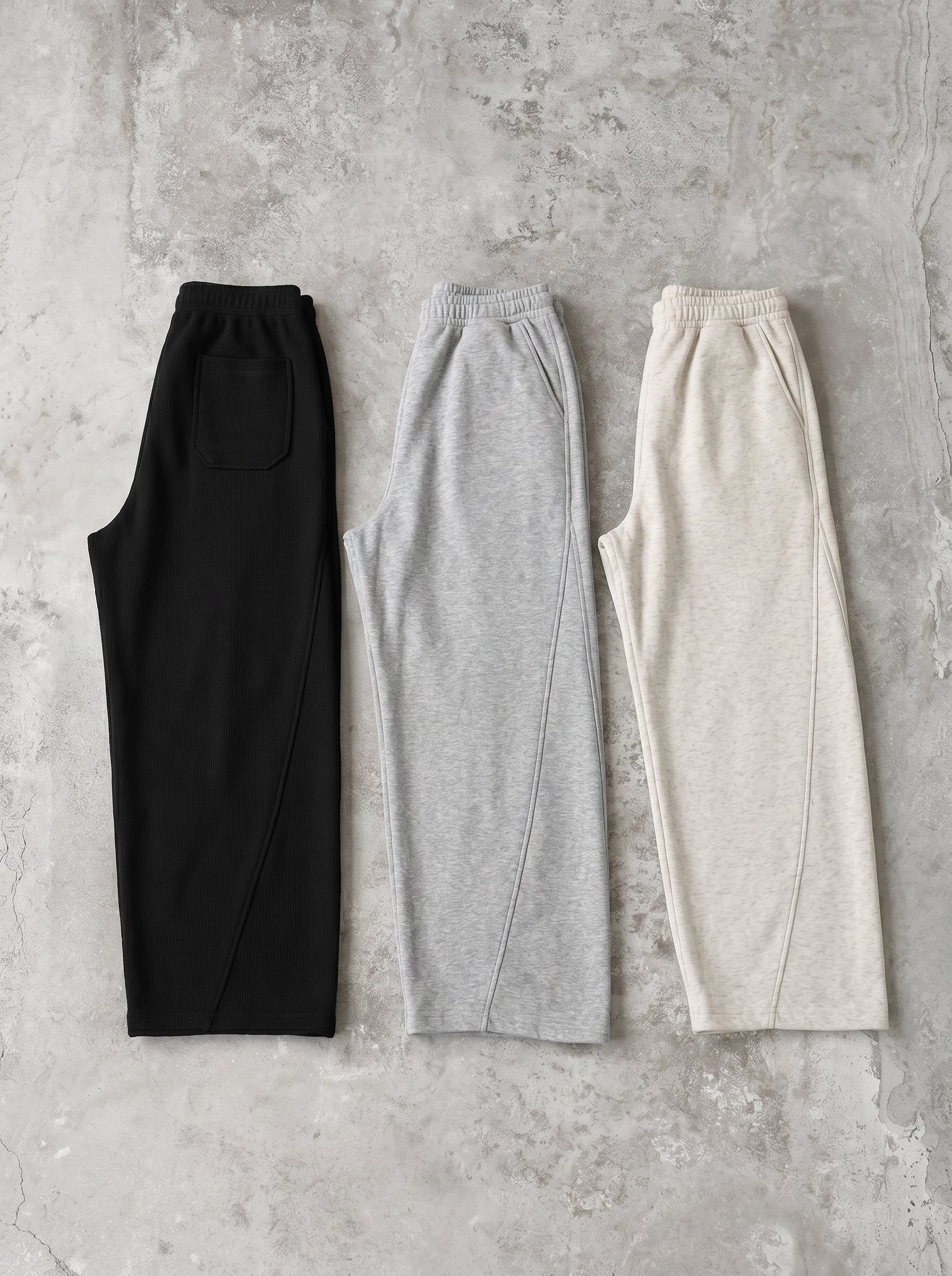 ブラックとグレーのワイドスウェットパンツ2色の平置き。ウエストはゴム＋ドローコード仕様。とろみのある落ち感で、裾に向かってドレープの出るワイドレッグシルエット。